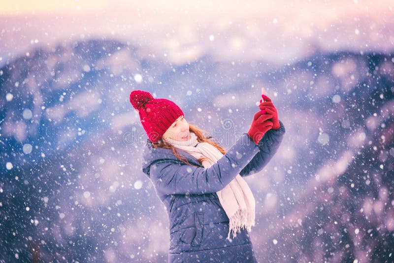 Beautiful smiling young woman in winter mountains at sunset, outdoor travel background, happy winter concept