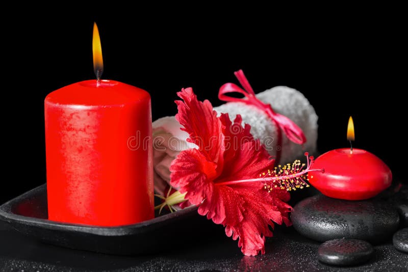 Beautiful spa still life of red hibiscus flower with dew, candle