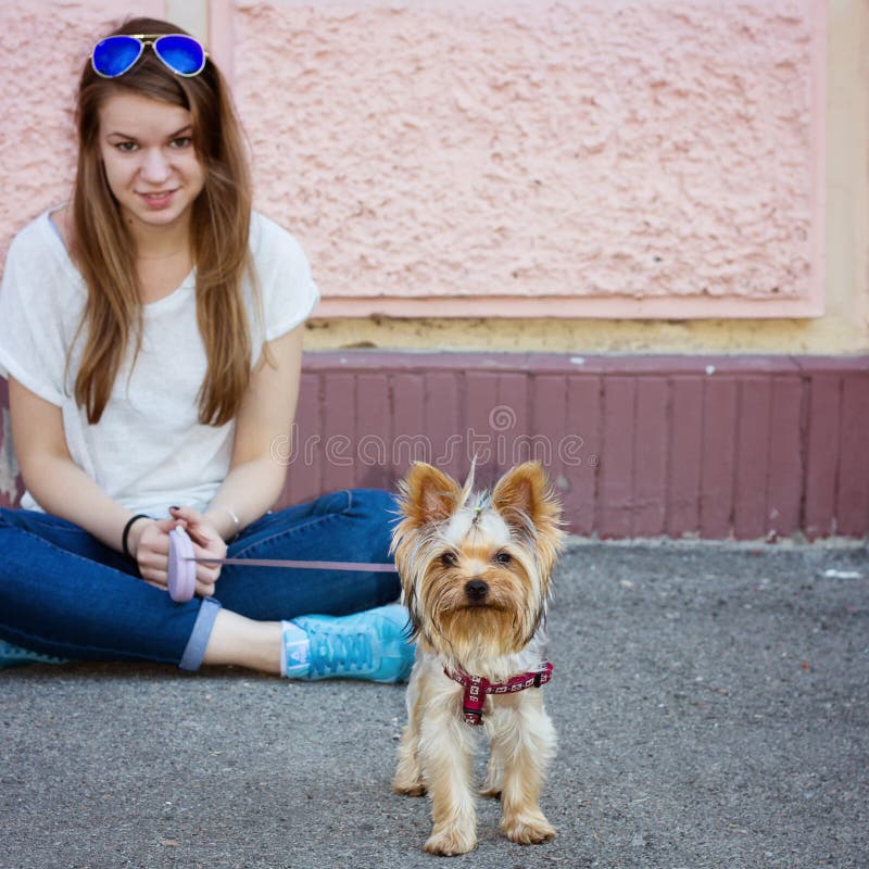 Beautiful sport woman sitting on the floor and Yorkshire terrier royalty free stock images Beautiful sport woman sitting on the floor and Yorkshire terrier royalty free stock images