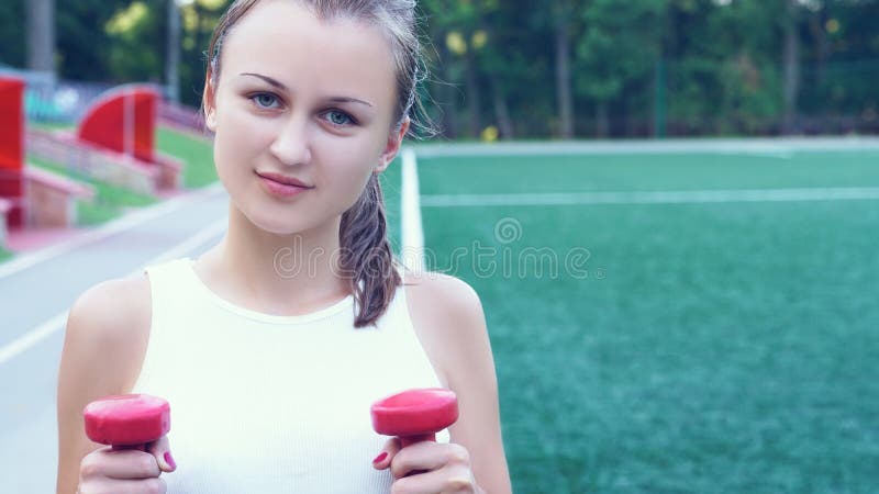 Beautiful Sporty Teenage Girl Goes In For Sports Iwith A Metal Dumbbell