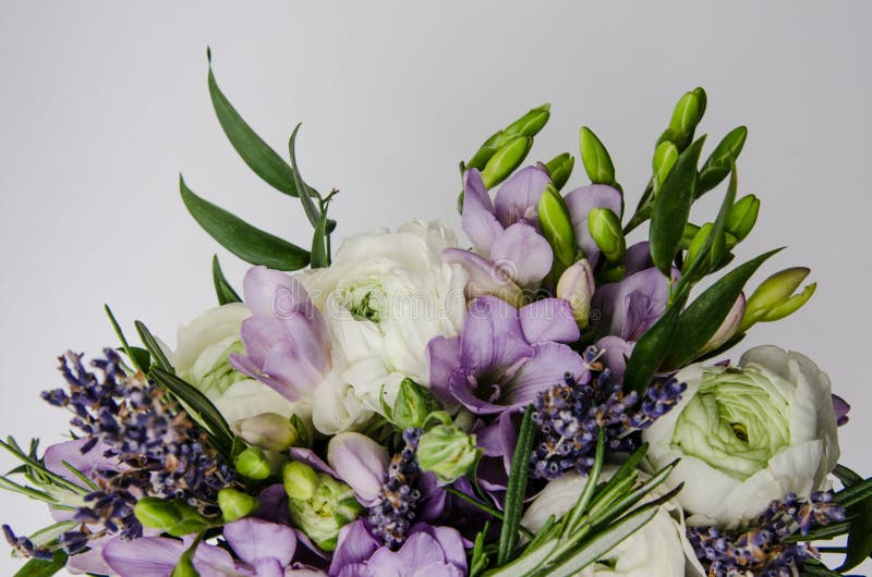 Beautiful spring bouquet of wedding flowers white, violet, green buttercup ranunculus, fresia. Background soft macro. Rustic style. Still life. Holiday wedding stock images Beautiful spring bouquet of wedding flowers white, violet, green buttercup ranunculus, fresia. Background soft macro. Rustic style. Still life. Holiday wedding stock images