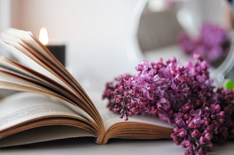 Beautiful spring flatlay. Spring atmosphere at home with lilac, book and candle