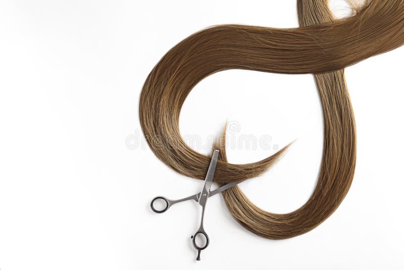 Beautiful strands of brown hair and scissors on white background. Hairdresser service