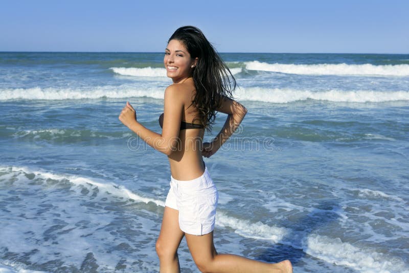 Beautiful summer girl jumping on the beach