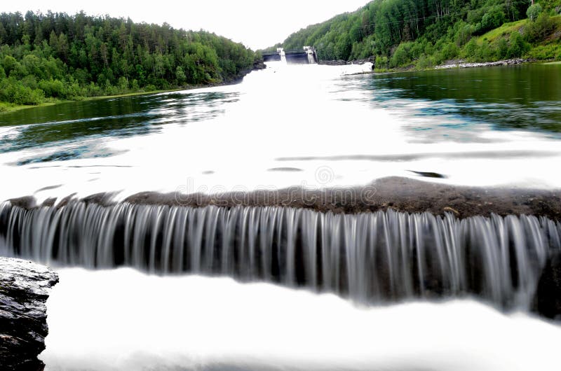 Beautiful summer landscape with waterfall, river flow and hydro electrical plate water gates