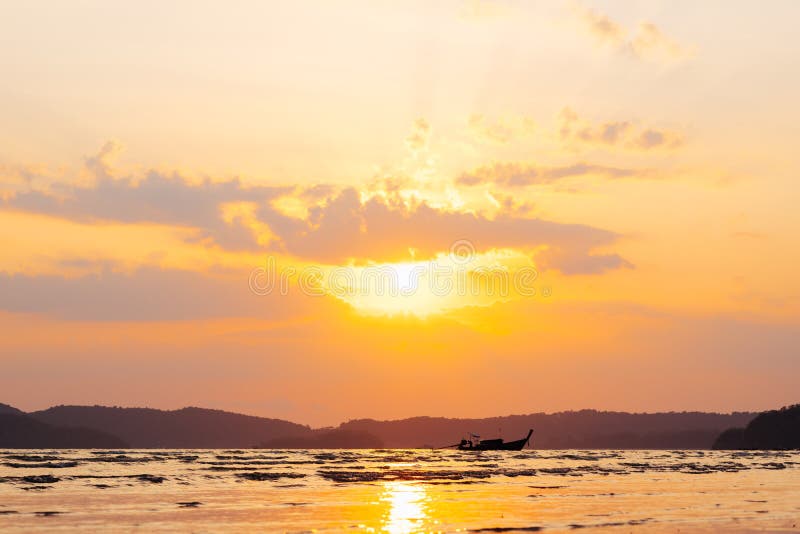 Beautiful summer sunset over sea with sunbeam through clouds above mountain and fishing boat. stock photography Beautiful summer sunset over sea with sunbeam through clouds above mountain and fishing boat. stock photography