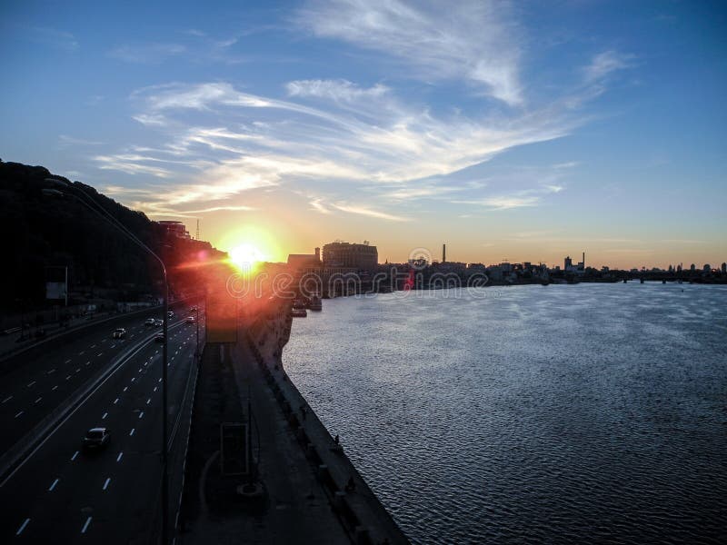 Beautiful sunset ander car route along the river. Kiev cityscape.