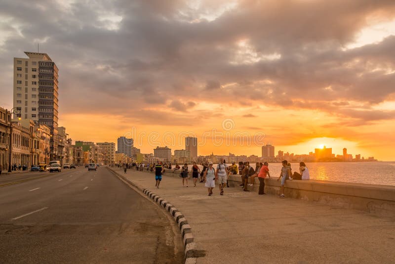 Beautiful sunset in Havana with a view of cubans and tourists along the Malecon avenue