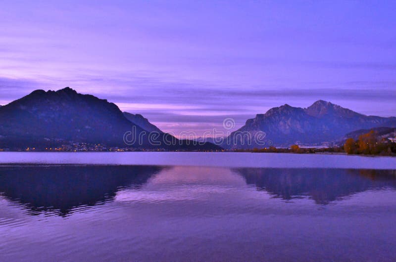 Sunset landscape of the river Adda at lake Garlate near Lecco with cloudscape and reflection of mountains.