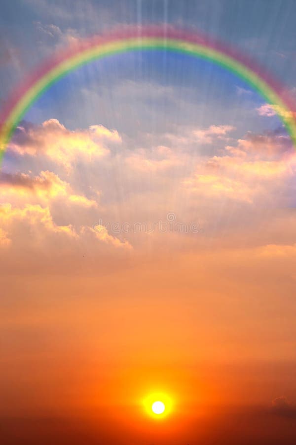 Image of beautiful sky at dusk with the glowing sun, colorful clouds and a rainbow for abstract background. Image of beautiful sky at dusk with the glowing sun, colorful clouds and a rainbow for abstract background.