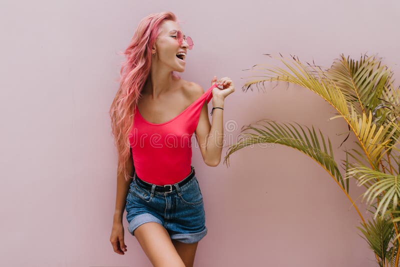 Beautiful Tanned Woman Playfully Posing Beside Palm Tree And Laughing Indoor Portrait Of 