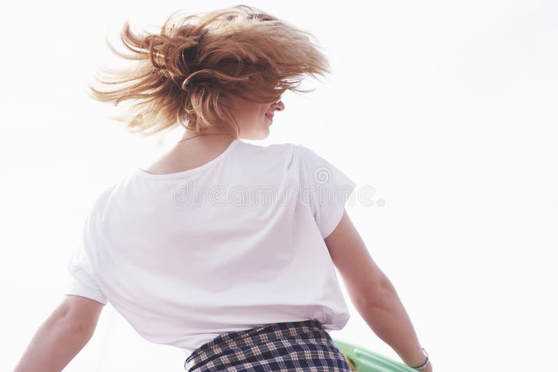 Beautiful teen female skater sitting on ramp at the skate park. Concept of summer urban activities royalty free stock photography Beautiful teen female skater sitting on ramp at the skate park. Concept of summer urban activities royalty free stock photography