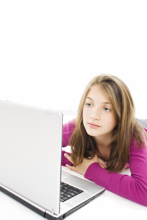 Beautiful teen girl lying on floor with a laptop