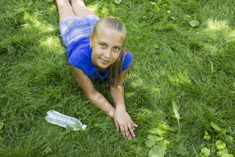 Teenage Girl in a Park Lying on Green Grass with Bottle of Wate Stock ...