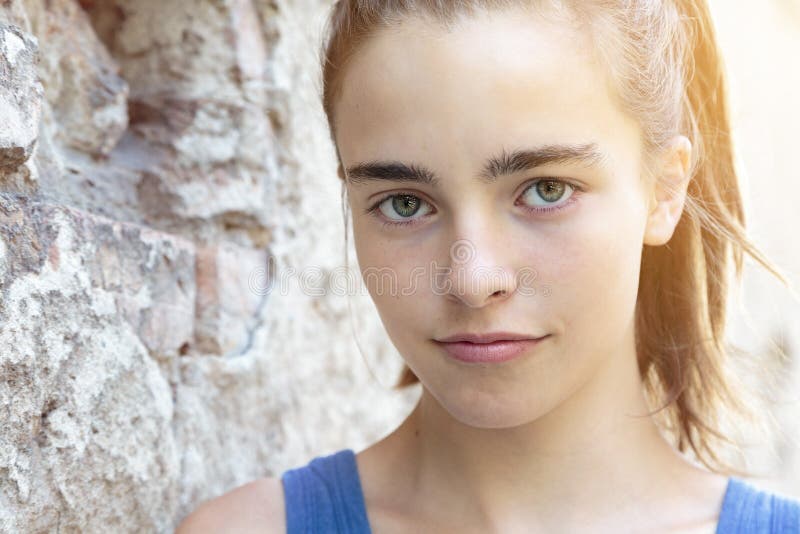 Beautiful teenager girl leaning against a wall