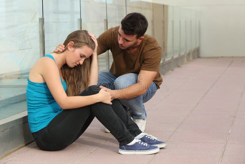 Beautiful teenager girl worried and a boy comforting her