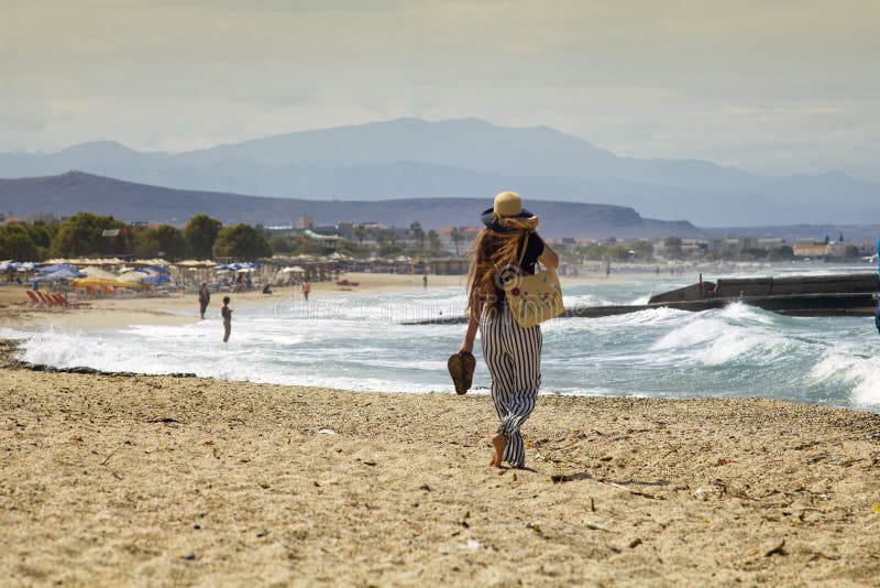 Beautiful teenager goes on the beach. The girl with her long hair is walking on the beach in Greece. stock photos Beautiful teenager goes on the beach. The girl with her long hair is walking on the beach in Greece. stock photos