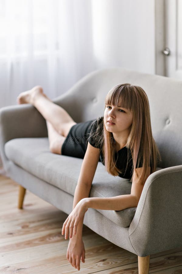 A Thoughtful European Girl of 8 Years Old Sitting on a Window Sill ...