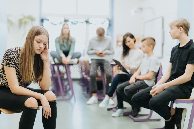 Thoughtful teenage girl sits on the side of a class during lesson at school