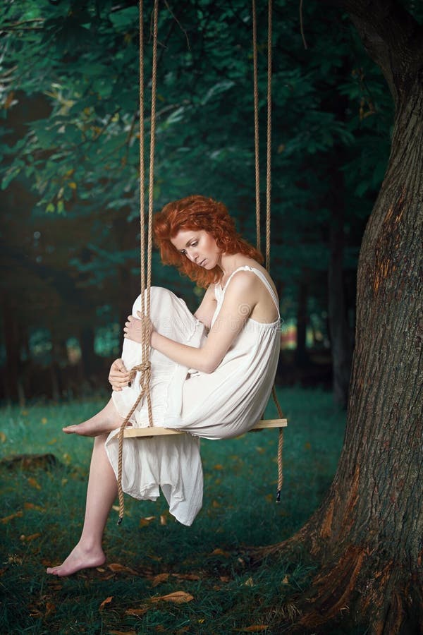 Beautiful thoughtful woman on a swing