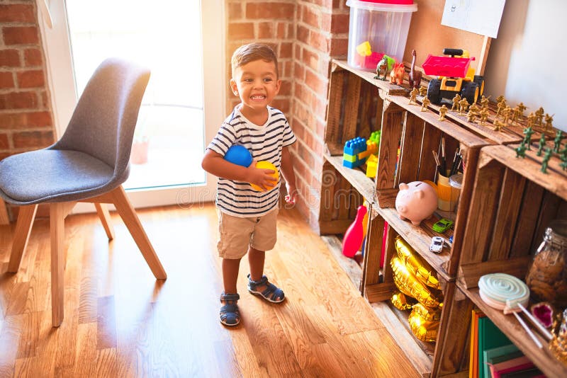 Beautiful Toddler Boy Playing with Colored Small Balls at Kindergarten