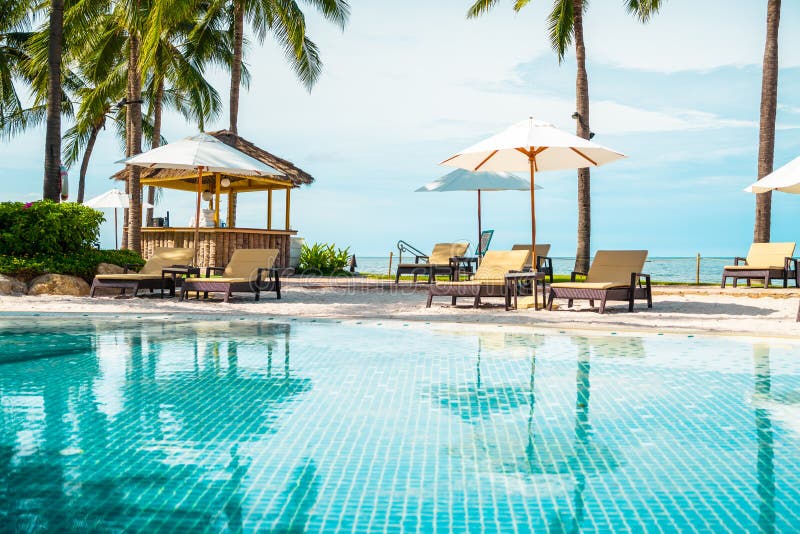 Beautiful tropical beach and sea with umbrella and chair around swimming pool in hotel resort for travel and vacation