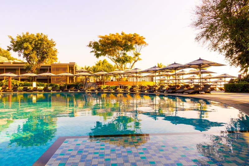 Beautiful tropical beach and sea with umbrella and chair around swimming pool in hotel resort for travel and vacation concept