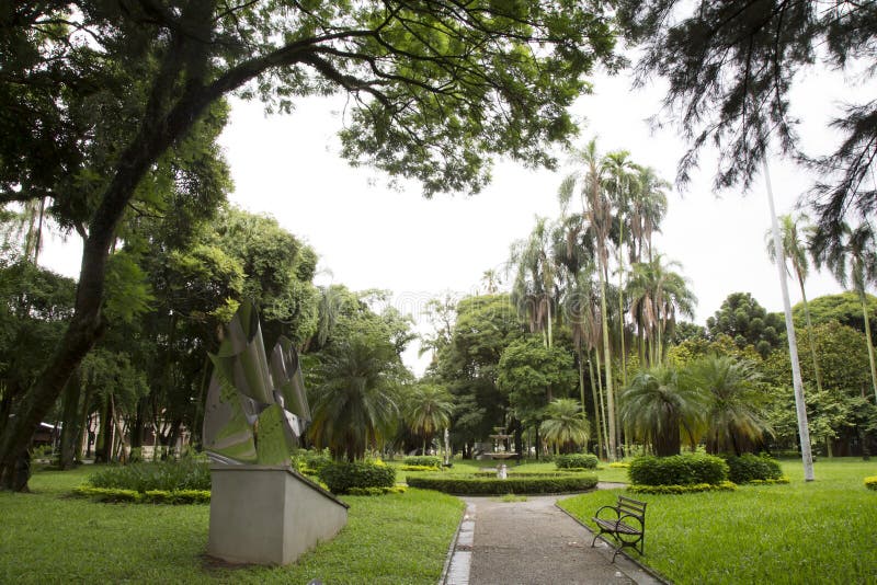 Beautiful tropical garden with bench and sculpture