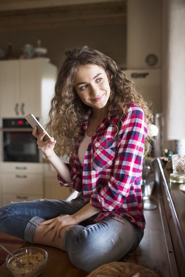 University student sitting at home on the floor scrolling on smartphone. royalty free stock photo