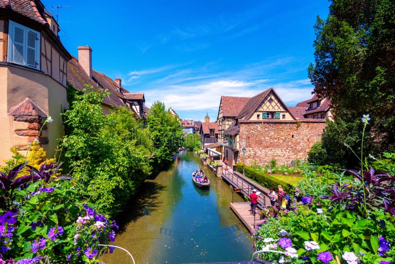 Beautiful view of the historic town of Colmar, also known as Little Venice, with tourists taking a boat ride along traditional colorful houses on idyllic river Lauch in summer, Colmar, Alsace, France. Beautiful view of the historic town of Colmar, also known as Little Venice, with tourists taking a boat ride along traditional colorful houses on idyllic river Lauch in summer, Colmar, Alsace, France.