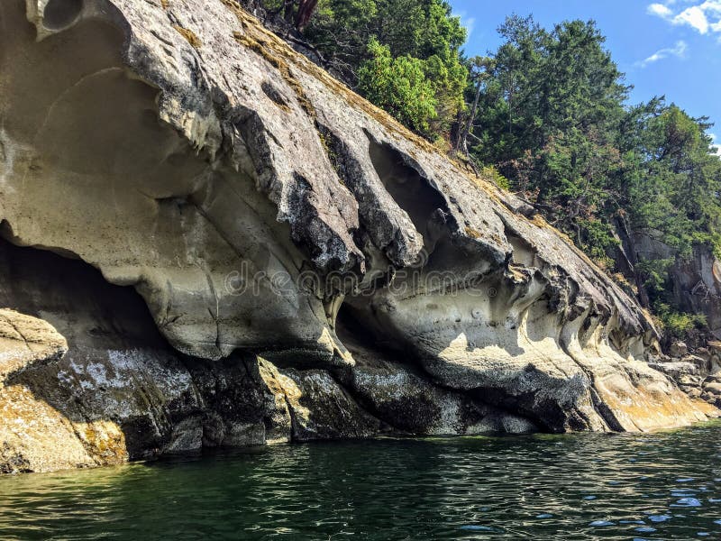 A beautiful view of a long shoreline of sea caves caused by coastal erosion on wallace island, in the gulf islands