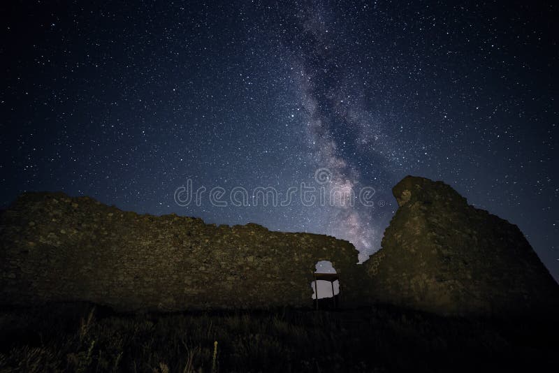 Beautiful view of Milky Way galaxy over the ruins of Enisala citadel in Romania, ancient medieval stronghold