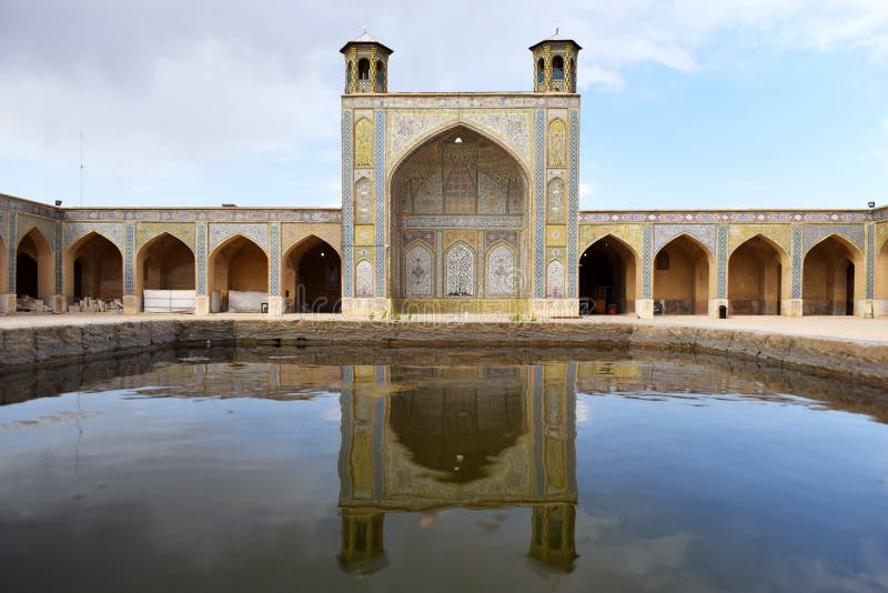 A beautiful view of the reflection of the architectural decorations of an ancient Iranian building on the water. Shiraz, Iran