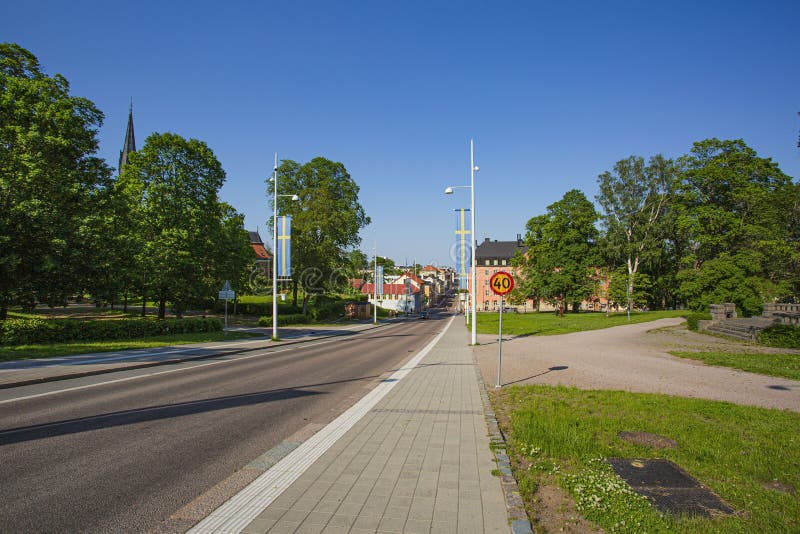 Beautiful view of town road with swedish flags during Swedish national day. Green trees and blue sky background. royalty free stock photo Beautiful view of town road with swedish flags during Swedish national day. Green trees and blue sky background. royalty free stock photo