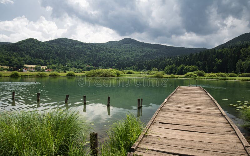Beautiful view with wooden footbridge on lake podpesko, slovenia royalty free stock photo Beautiful view with wooden footbridge on lake podpesko, slovenia royalty free stock photo