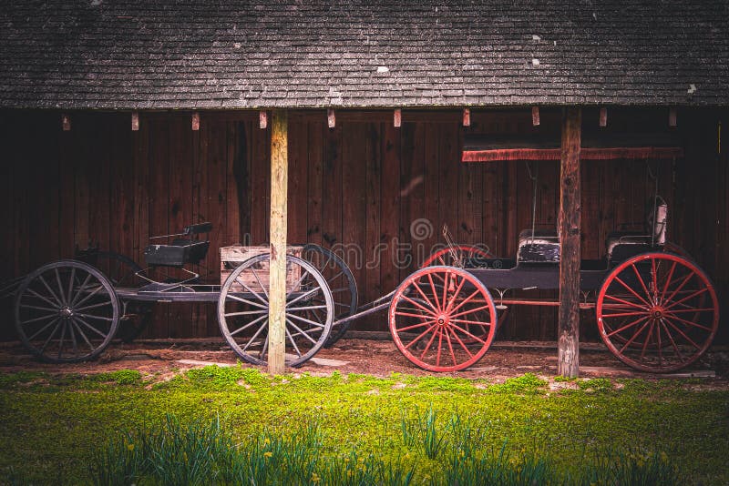 Two beautiful vintage horse cart trap vehicle next to a rustic barn stable building. Stable rustic style stock images, royalty-free photos and pictures