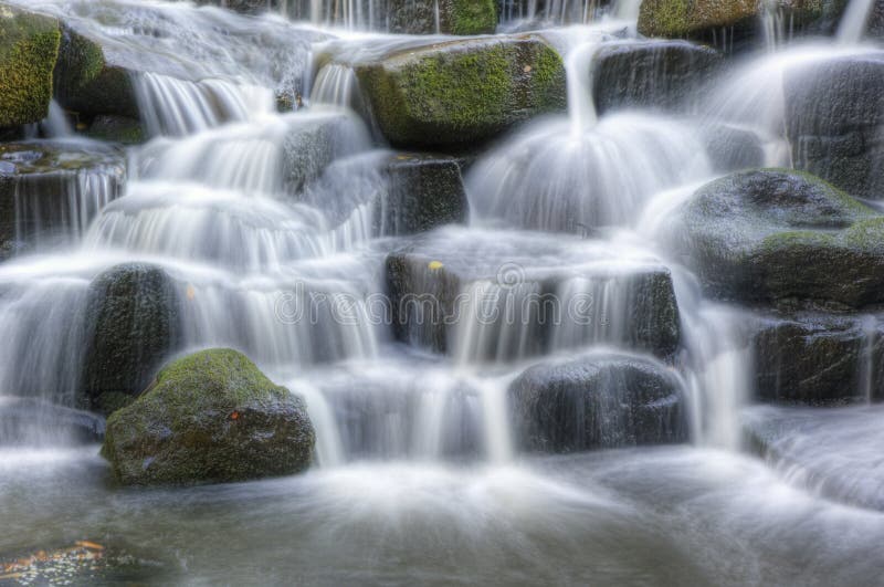 Beautiful waterfall cascades over rocks in forest royalty free stock photography