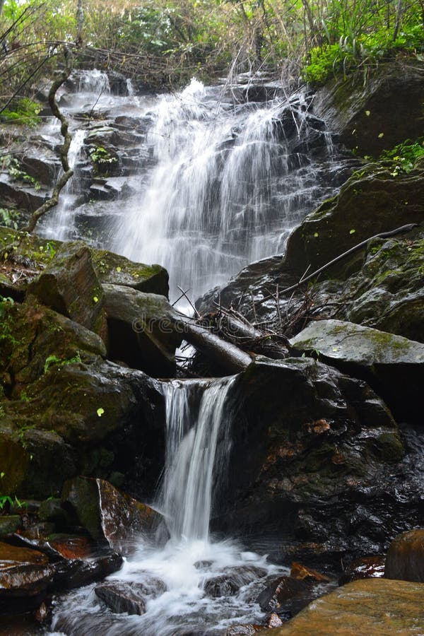 Beautiful Waterfall Flowing Down the Slippery Rocks Covered in Moss in