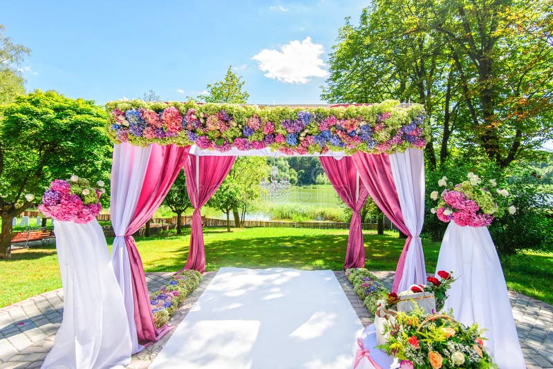 Beautiful wedding arch with flowers in garden stock photo