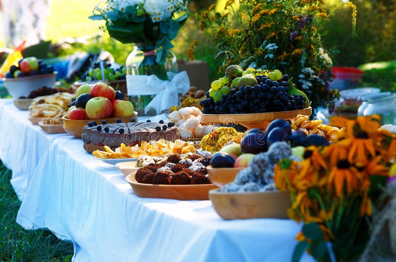 Beautiful wedding feast in nature, abundance of meals on a table.