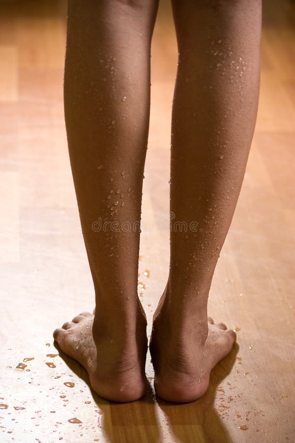 Beautiful and wet female legs on wooden floor