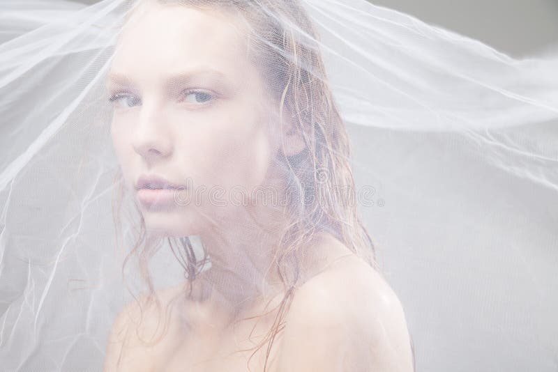 Beautiful wet woman face with waving fabric