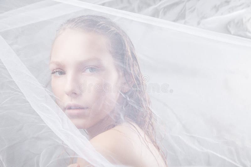 Beautiful wet woman face with waving fabric