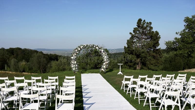 Beautiful white arch for a wedding ceremony stands outdoors