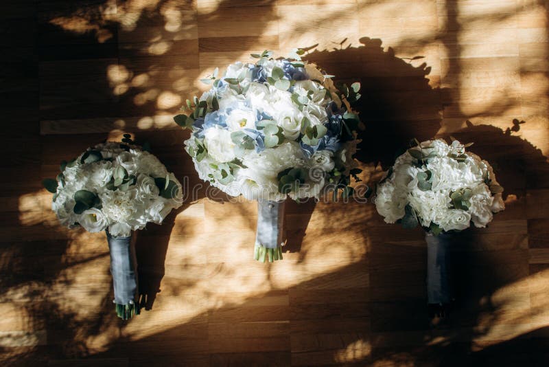 Beautiful white and blue roses wedding bouquets for bride and bridesmaids closeup, fresh white flowers bouquet on wooden royalty free stock photography Beautiful white and blue roses wedding bouquets for bride and bridesmaids closeup, fresh white flowers bouquet on wooden royalty free stock photography