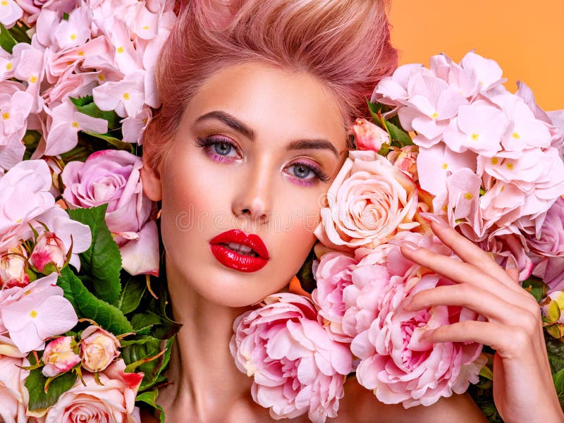 Beautiful white girl with flowers. Stunning blonde girl with big bouquet flowers of roses. Closeup face of young beautiful woman