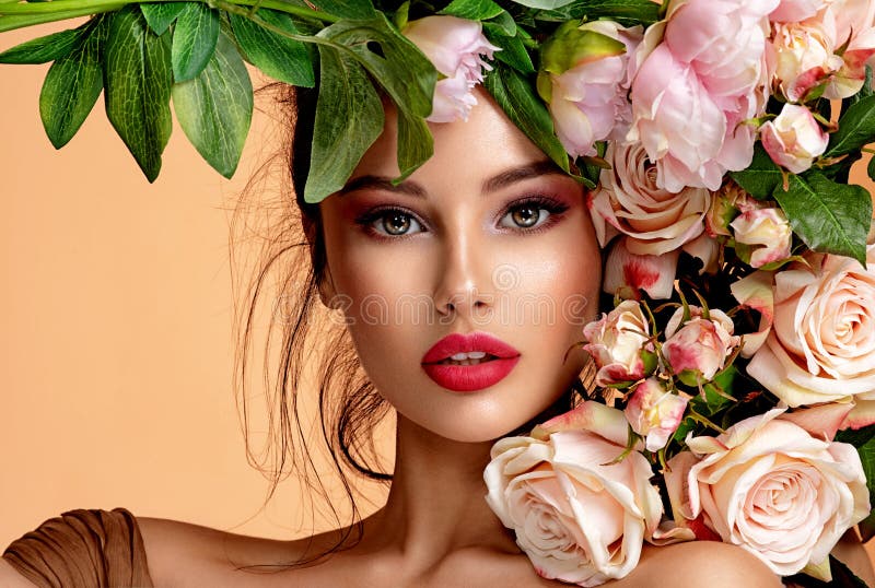 Beautiful white girl with flowers. Stunning brunette girl with big bouquet flowers of roses. Closeup face of young beautiful woman