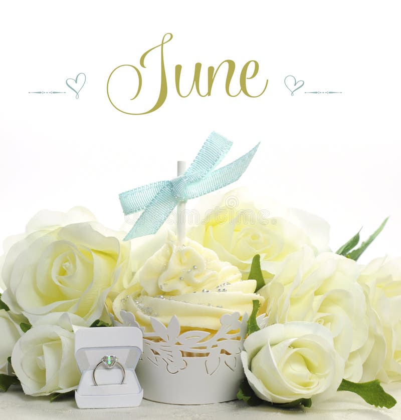 Beautiful white June Bride theme cupcake with seasonal flowers and decorations for the month of June