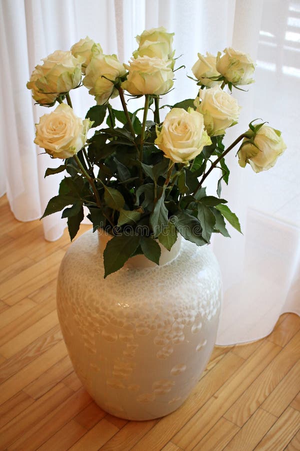Beautiful White Roses in a Large White Vase on the Floor Stock Photo