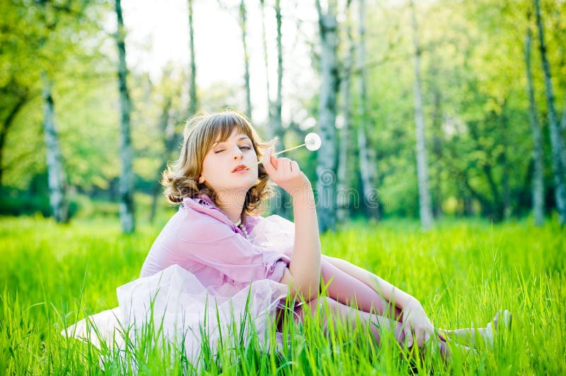 Beautiful winking girl with dandelion